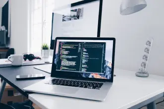 Website design mockup and development tools on a desk
