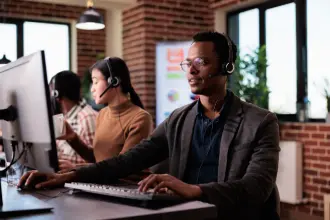 African tech support professional at a desk assisting a client